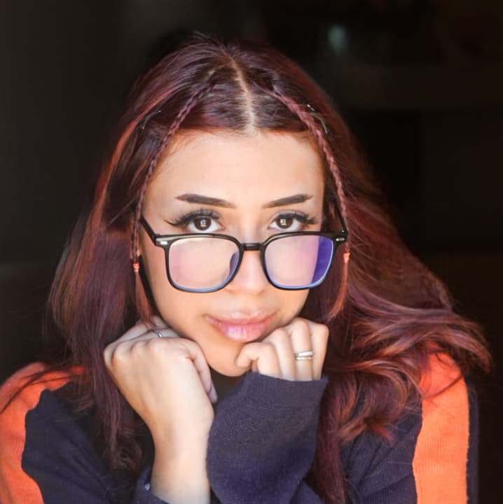 a woman wearing glasses and a sweater